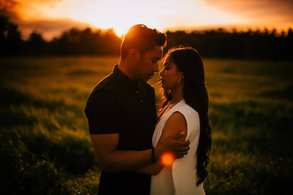 Fish Creek Calgary engagement shoot couple with the sun setting in the background