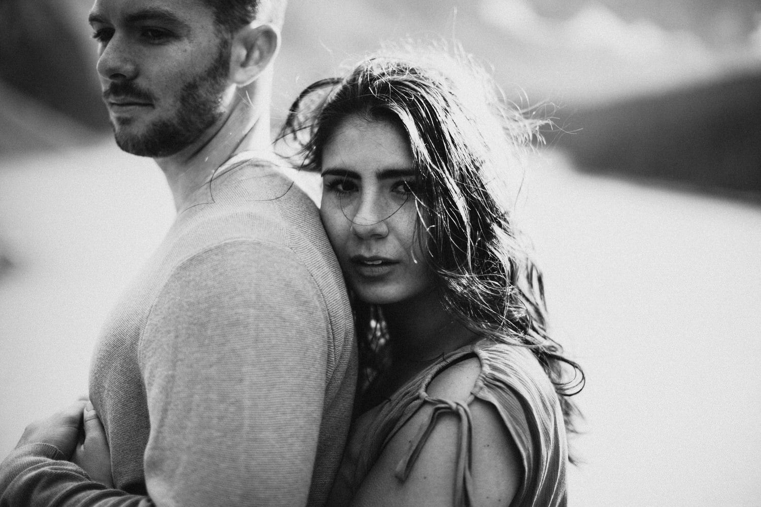 A lady holding her man during an engagement shoot at Moraine Lake