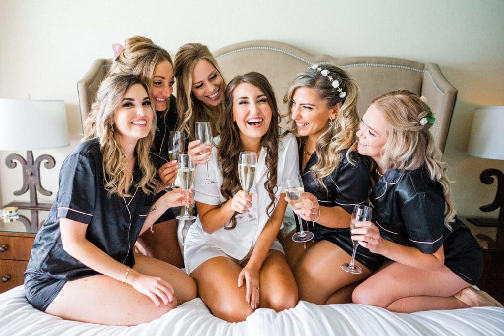 Bride and Bridesmaids drinking champagne as they get ready