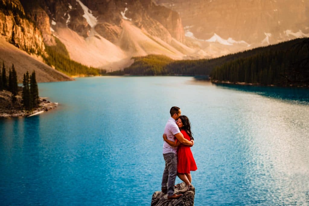 A newly engaged couple at Moraine Lake  on a rock