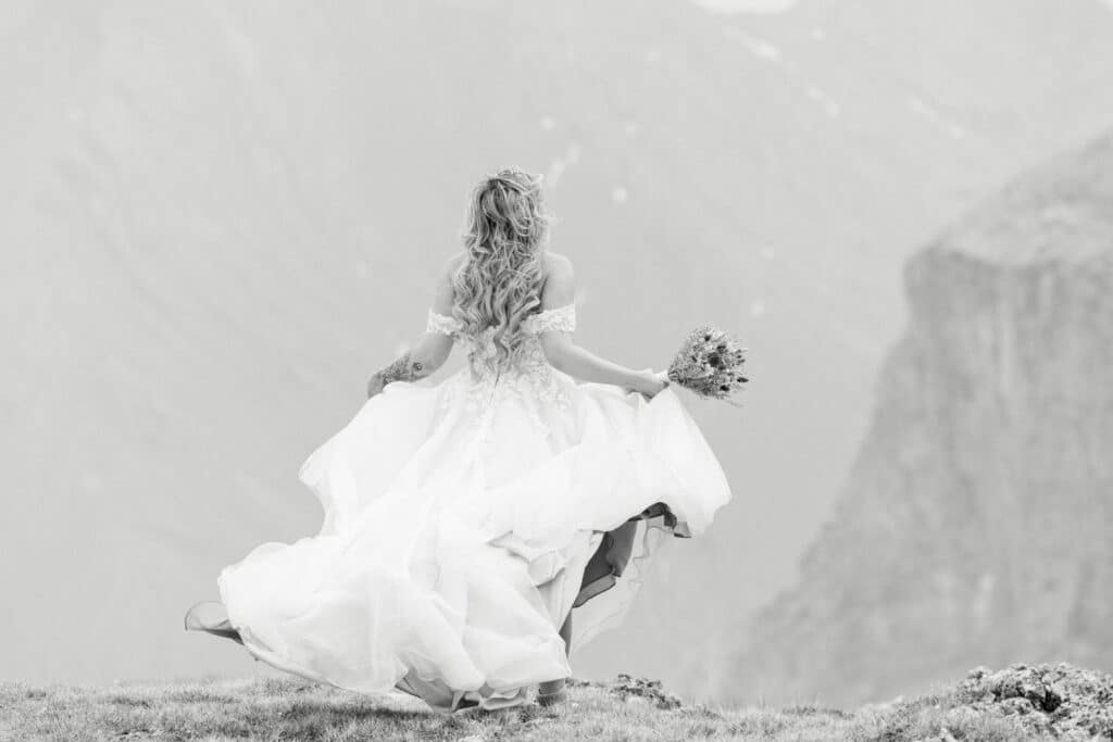 Winds pick up on top of the mountain during an elopement and the dress of the pride starts to dance