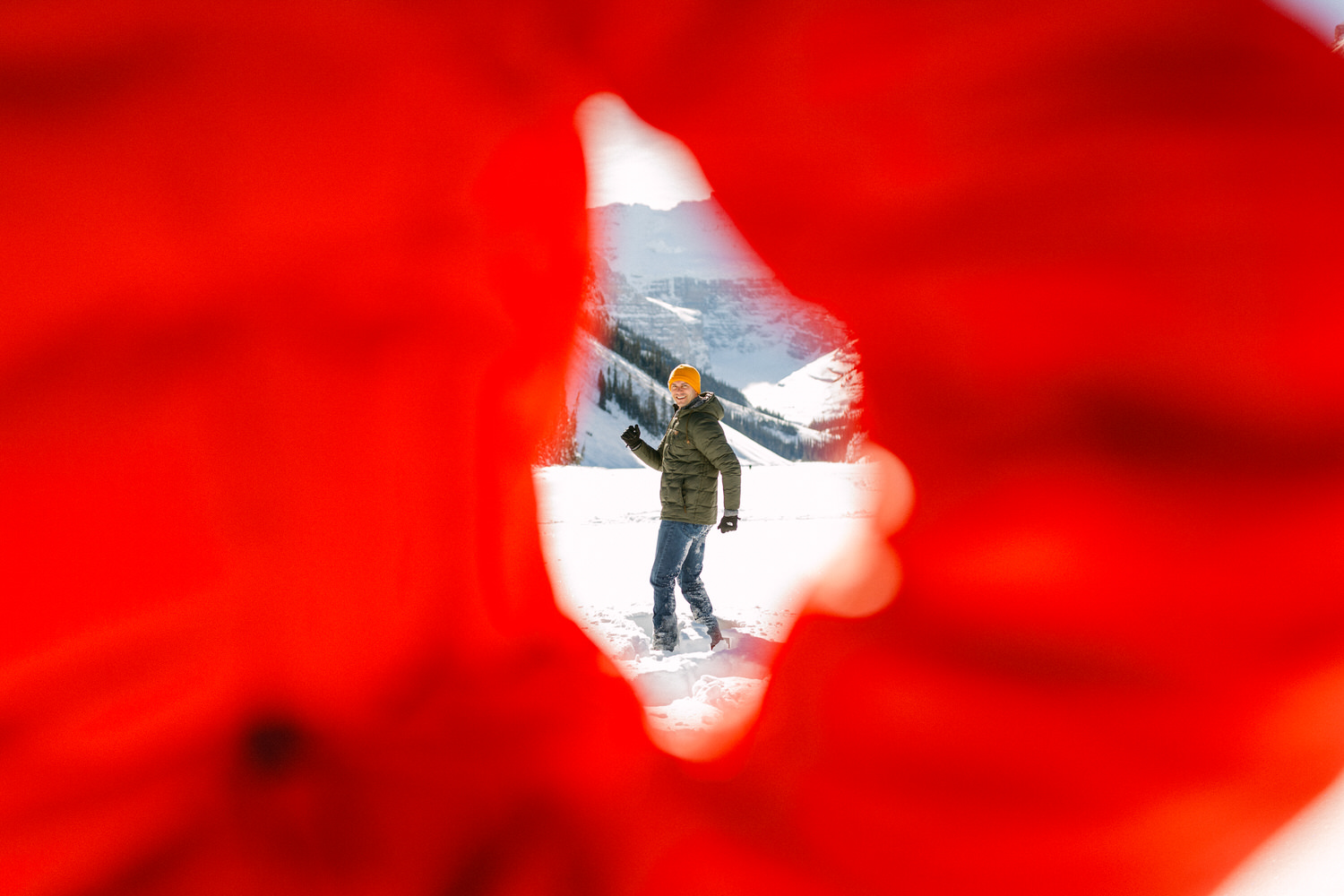 Person framed by a heart shape with snowy mountain landscape in the background.