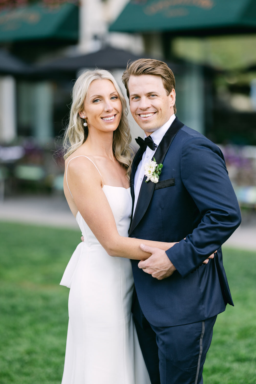 A happy couple in wedding attire posing for a portrait outdoors