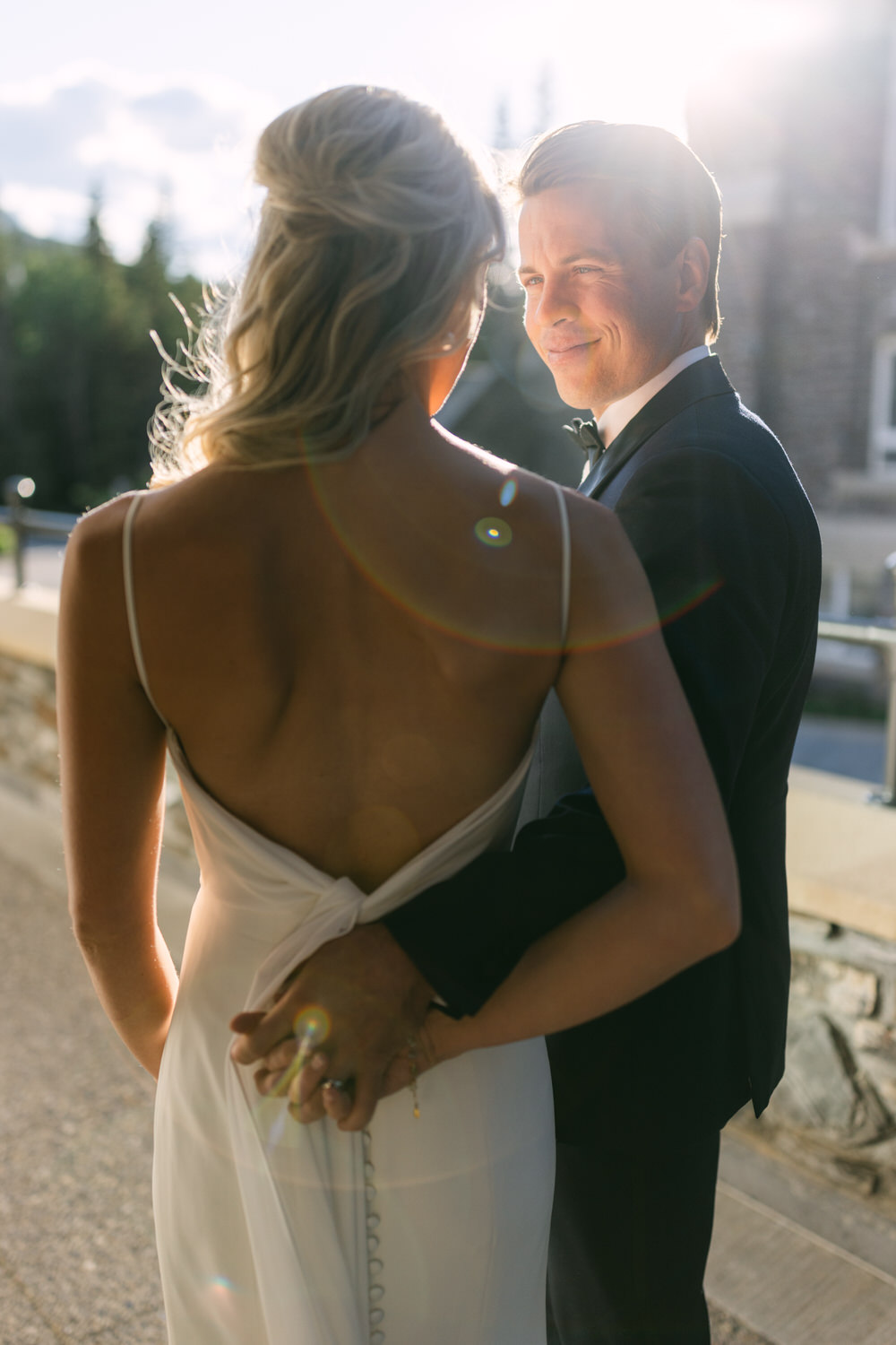 A bride and groom sharing an intimate moment in the warm sunlight