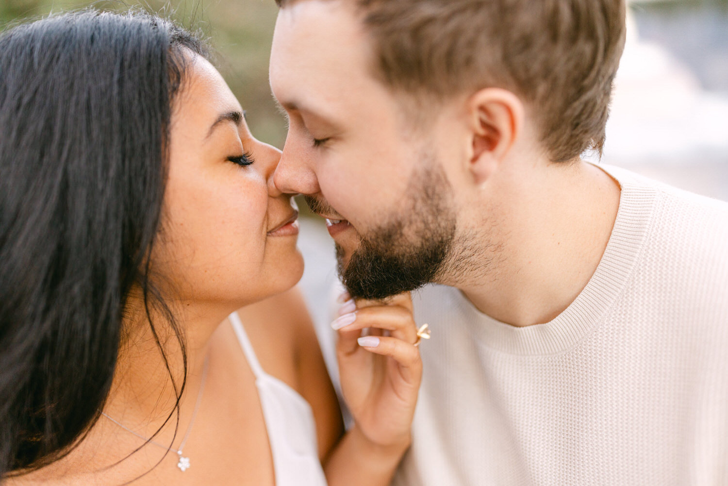 A close-up of a man and woman affectionately touching noses with eyes closed.