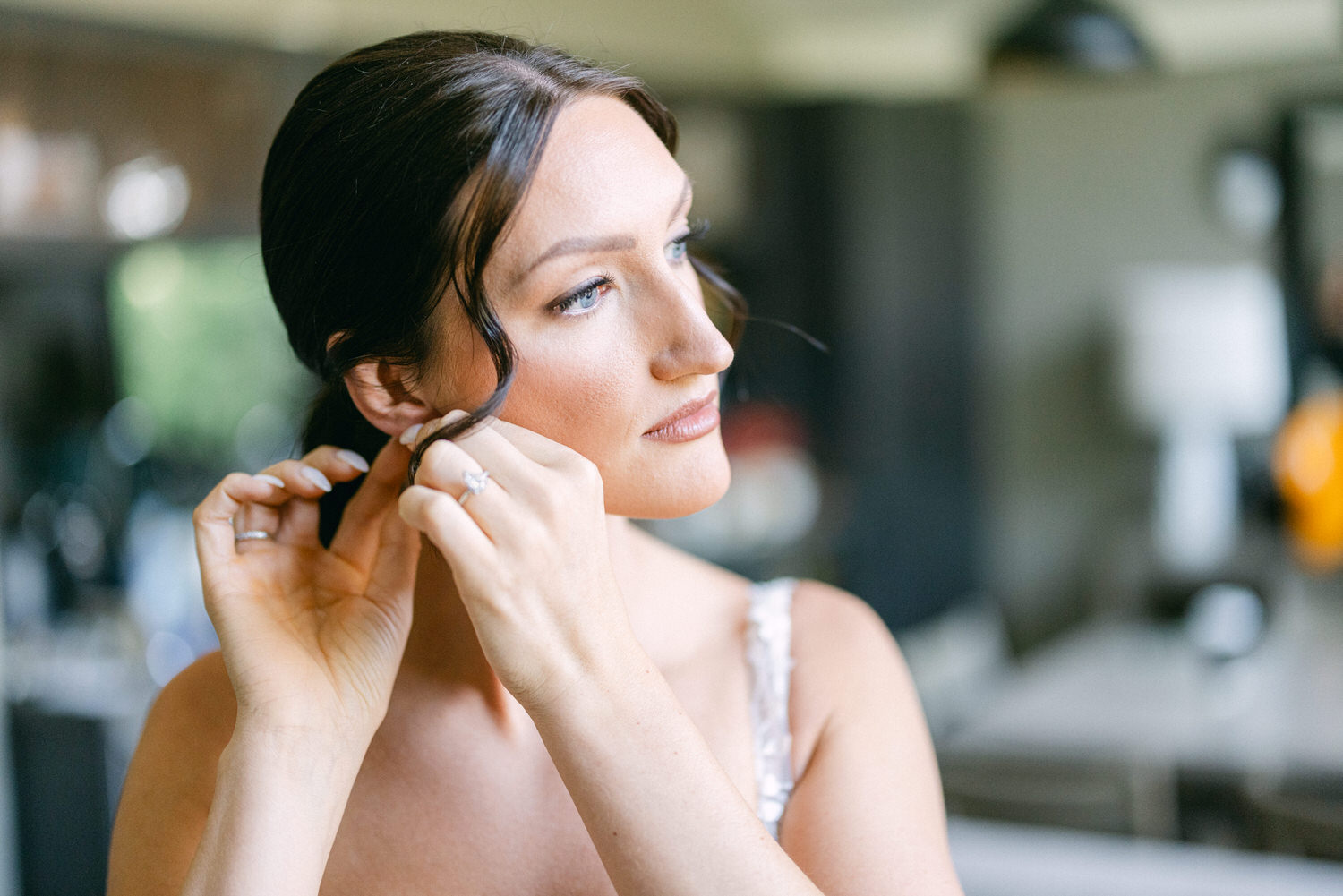 A woman elegantly styling her hair while getting ready for her wedding, showcasing focus and grace.