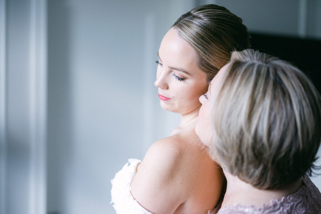 A bride and her mother share a heartfelt moment, showcasing love and support before the ceremony.