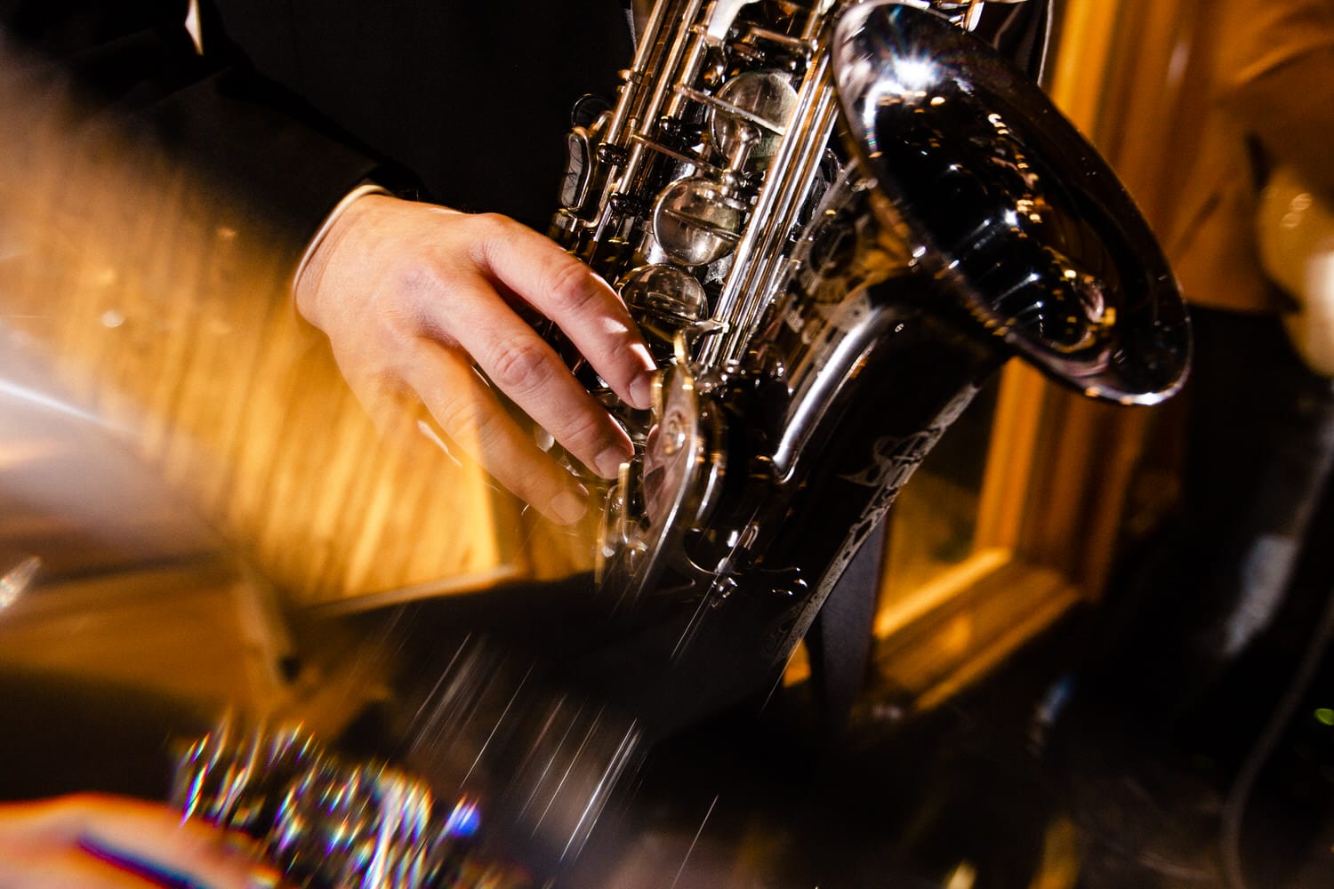 Close-up of a musician's hand skillfully playing a saxophone, showcasing musical precision and artistry.