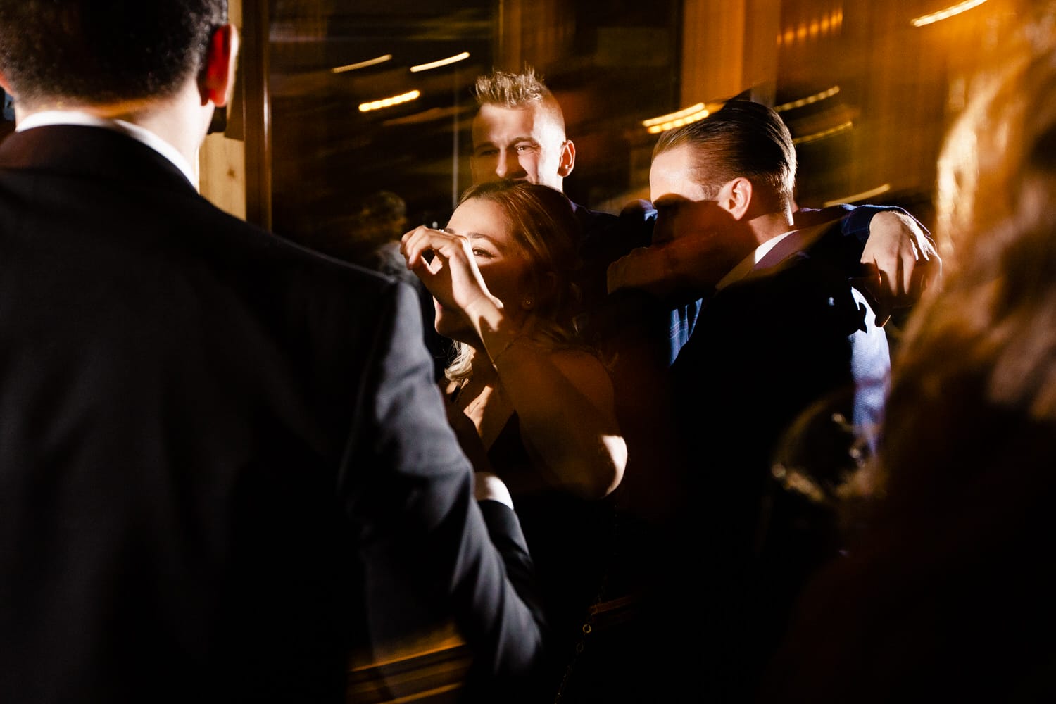 A lively gathering with people dancing and enjoying themselves in a dimly lit setting.