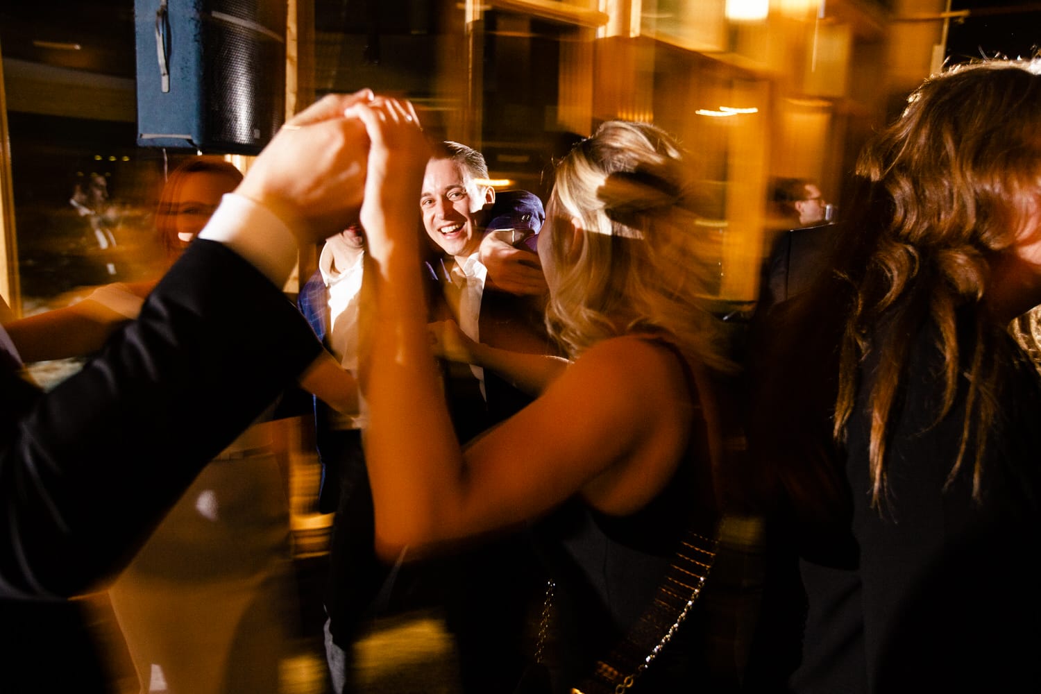 A lively gathering with people dancing joyfully, captured in a dynamic, blurred motion effect, showcasing happiness and excitement.