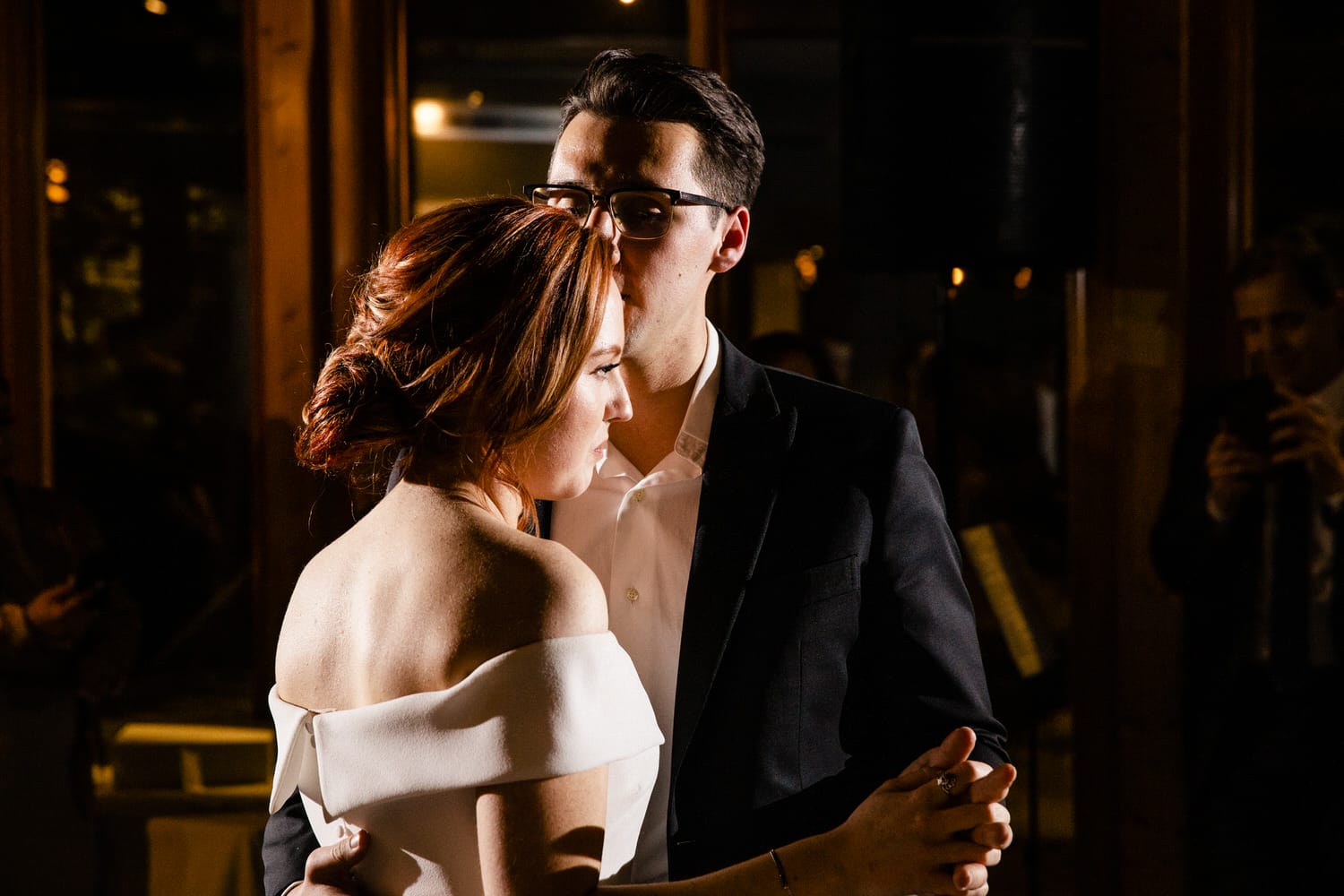 A couple sharing a heartfelt dance, illuminated by soft lighting, capturing a romantic atmosphere.