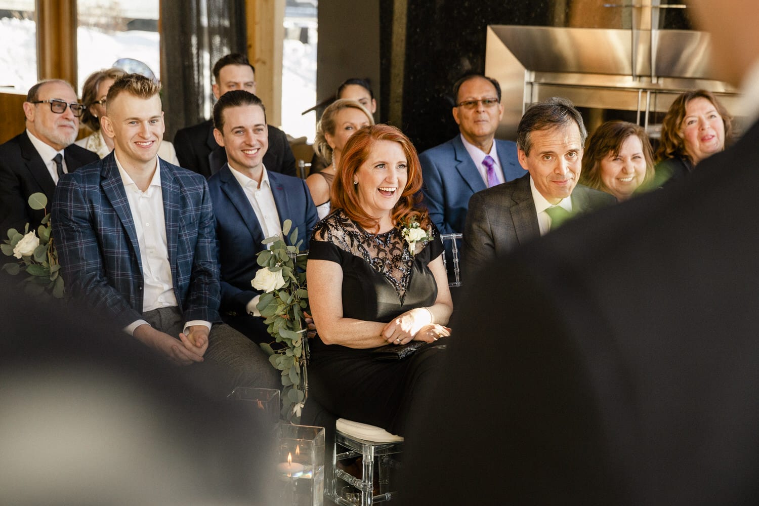 Guests enjoying a heartfelt moment during a wedding ceremony, showcasing laughter and joy among attendees.