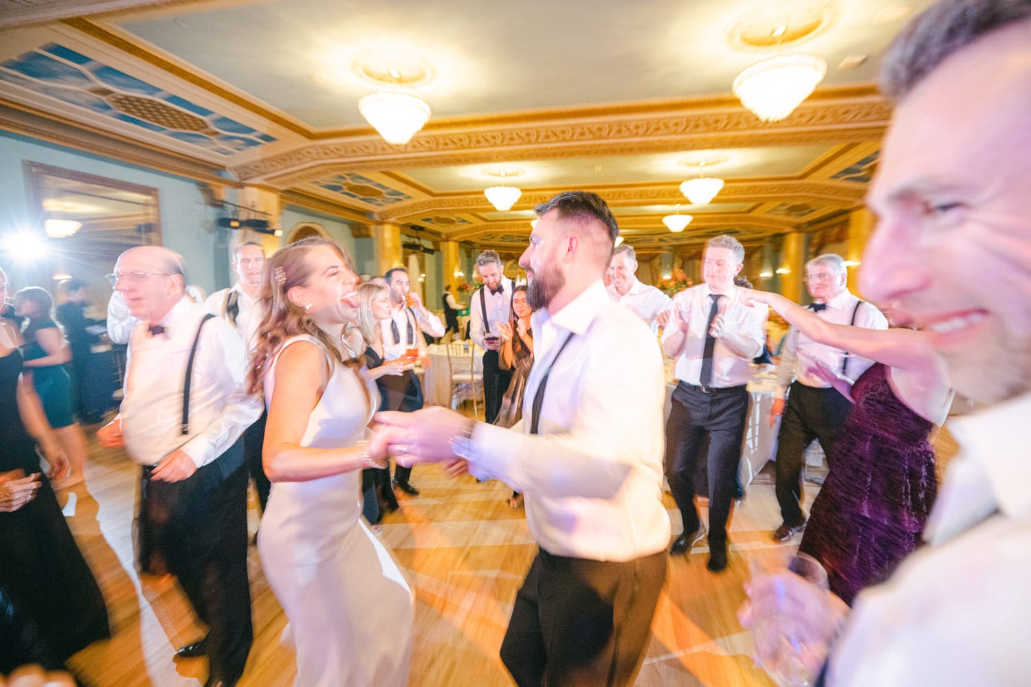 Guests enjoy an elegant dance party in a beautifully decorated venue, laughter and energy filling the air as they celebrate together.