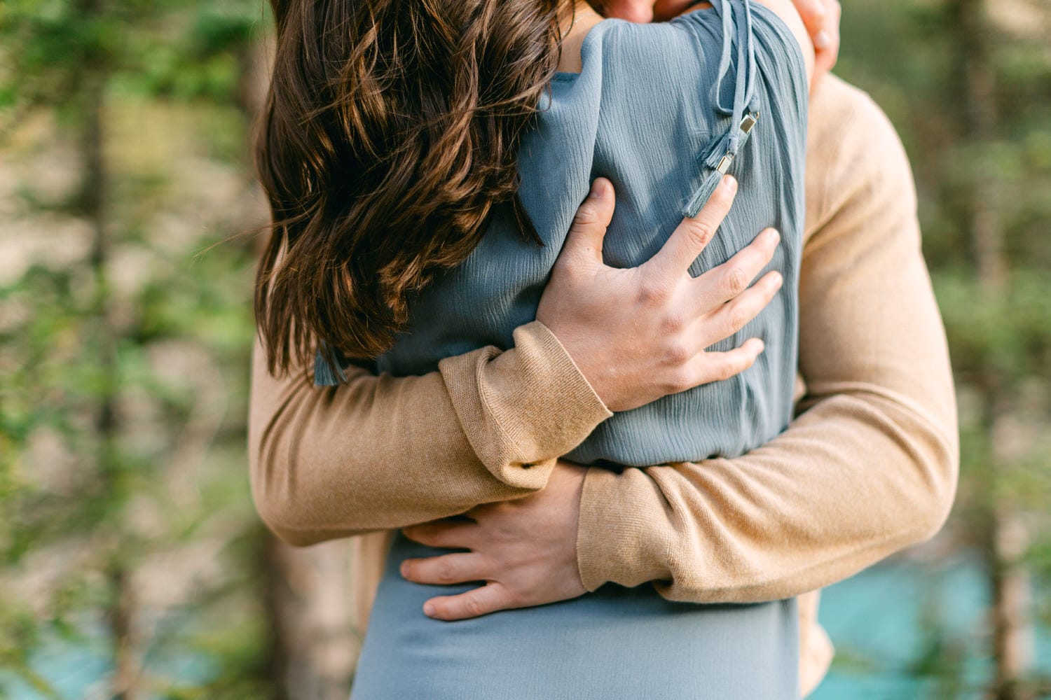 A close-up of a couple hugging warmly in an outdoor setting, showcasing their connection and affection.