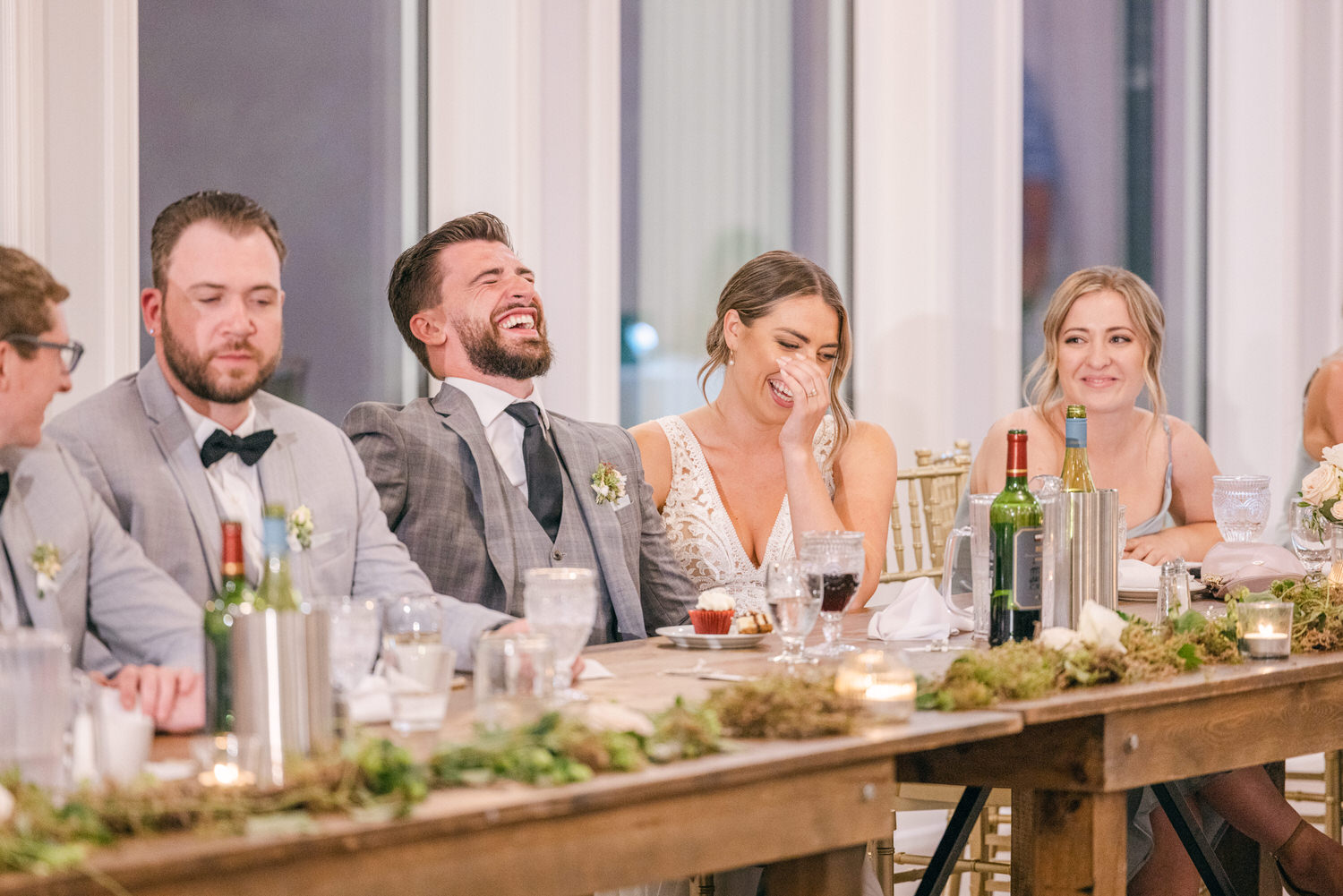 Guests enjoying laughter and conversation at a beautifully decorated wedding reception table.