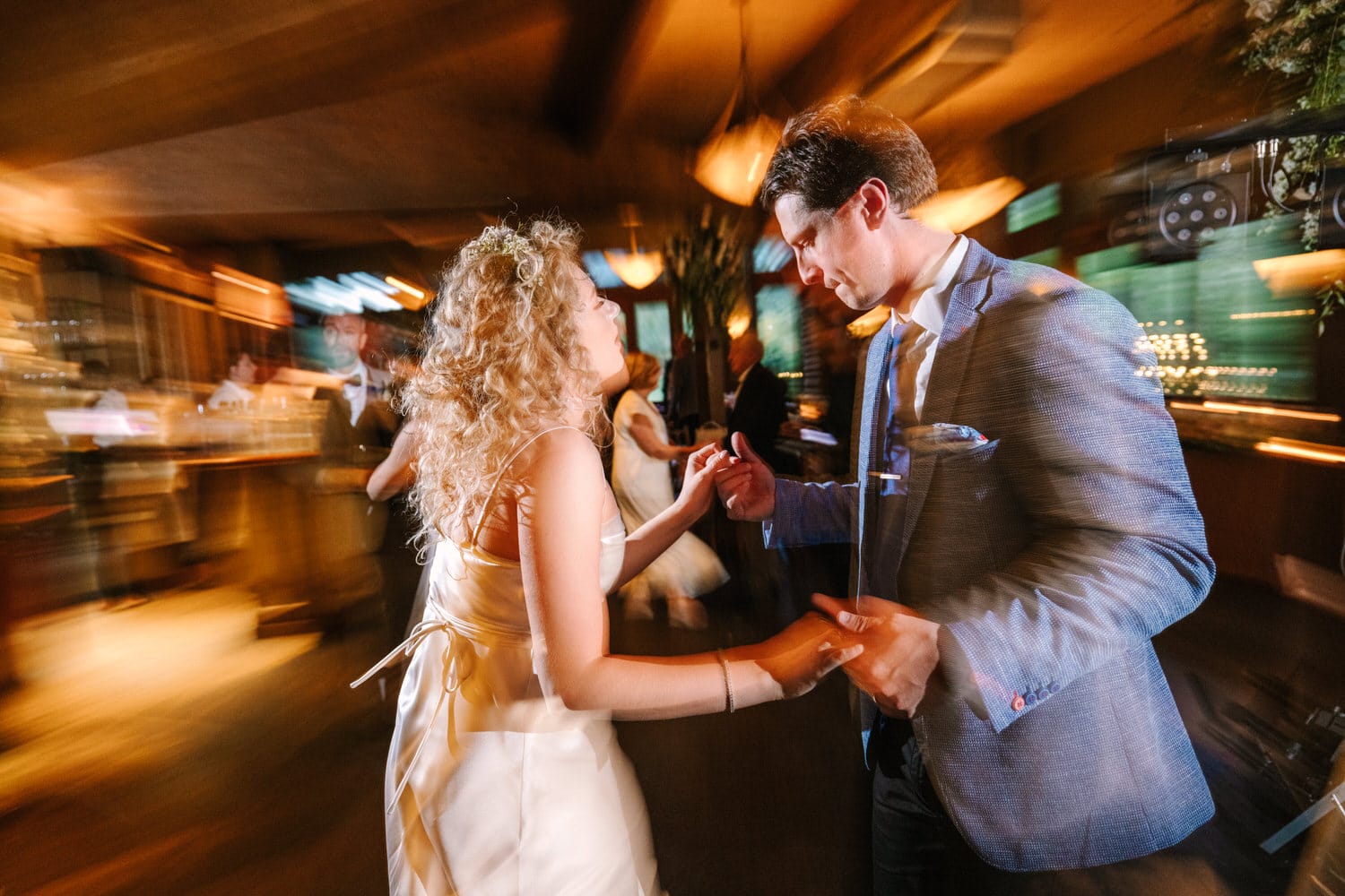 A couple enjoys a lively moment on the dance floor, with motion blur capturing the energy of the celebration.