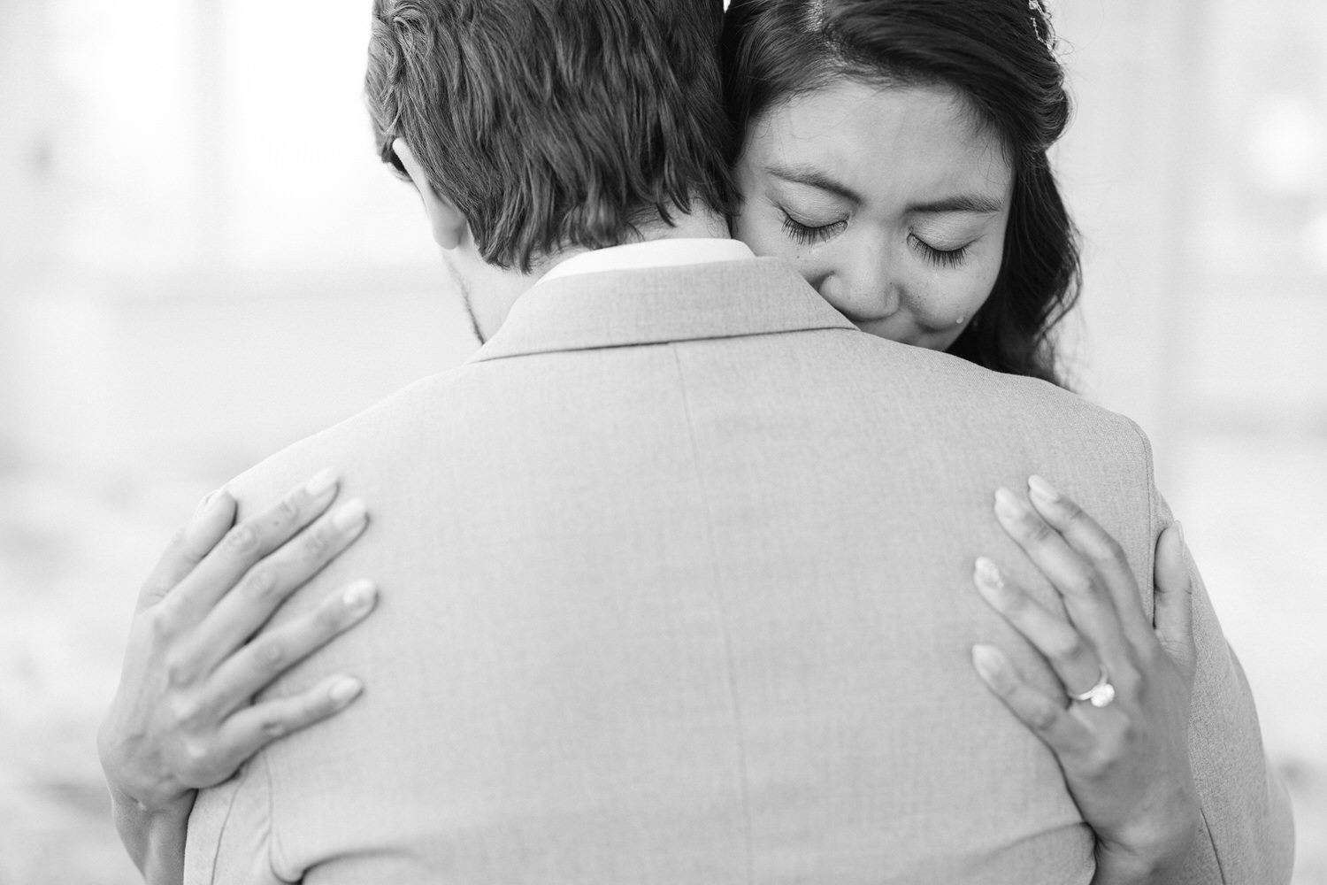 A couple sharing a heartfelt moment, captured in black and white, highlighting affection and intimacy as they hold each other closely.