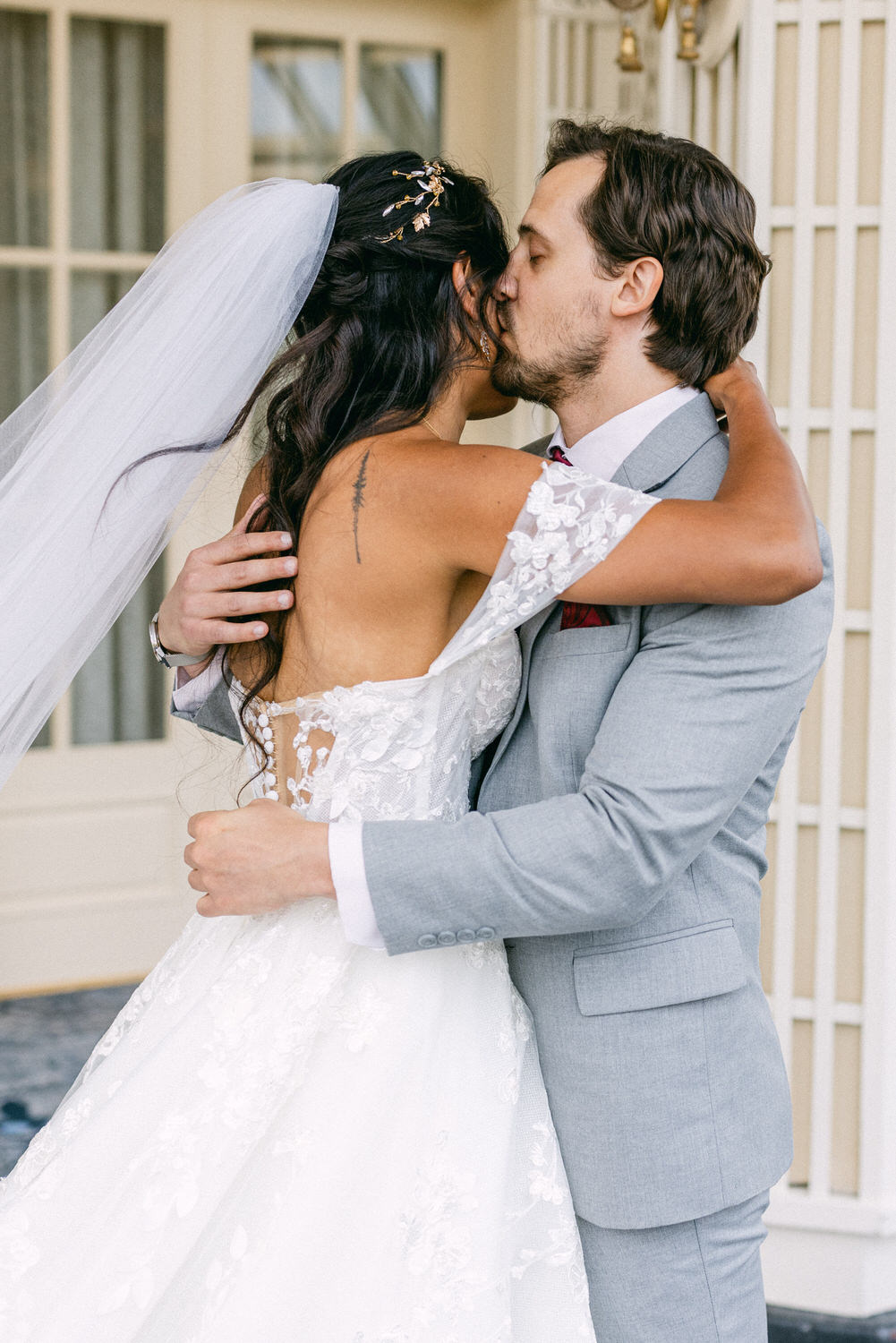 Bride and groom sharing a tender kiss, showcasing affection in a beautifully decorated setting.