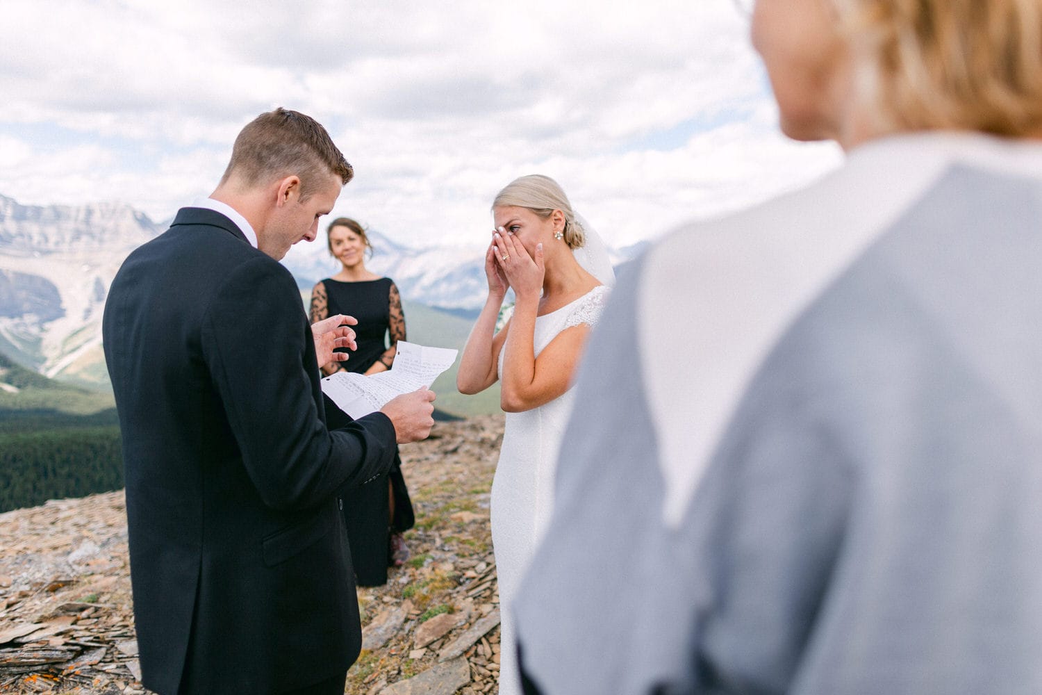 A couple shares heartfelt vows during an emotional outdoor wedding ceremony in the mountains.