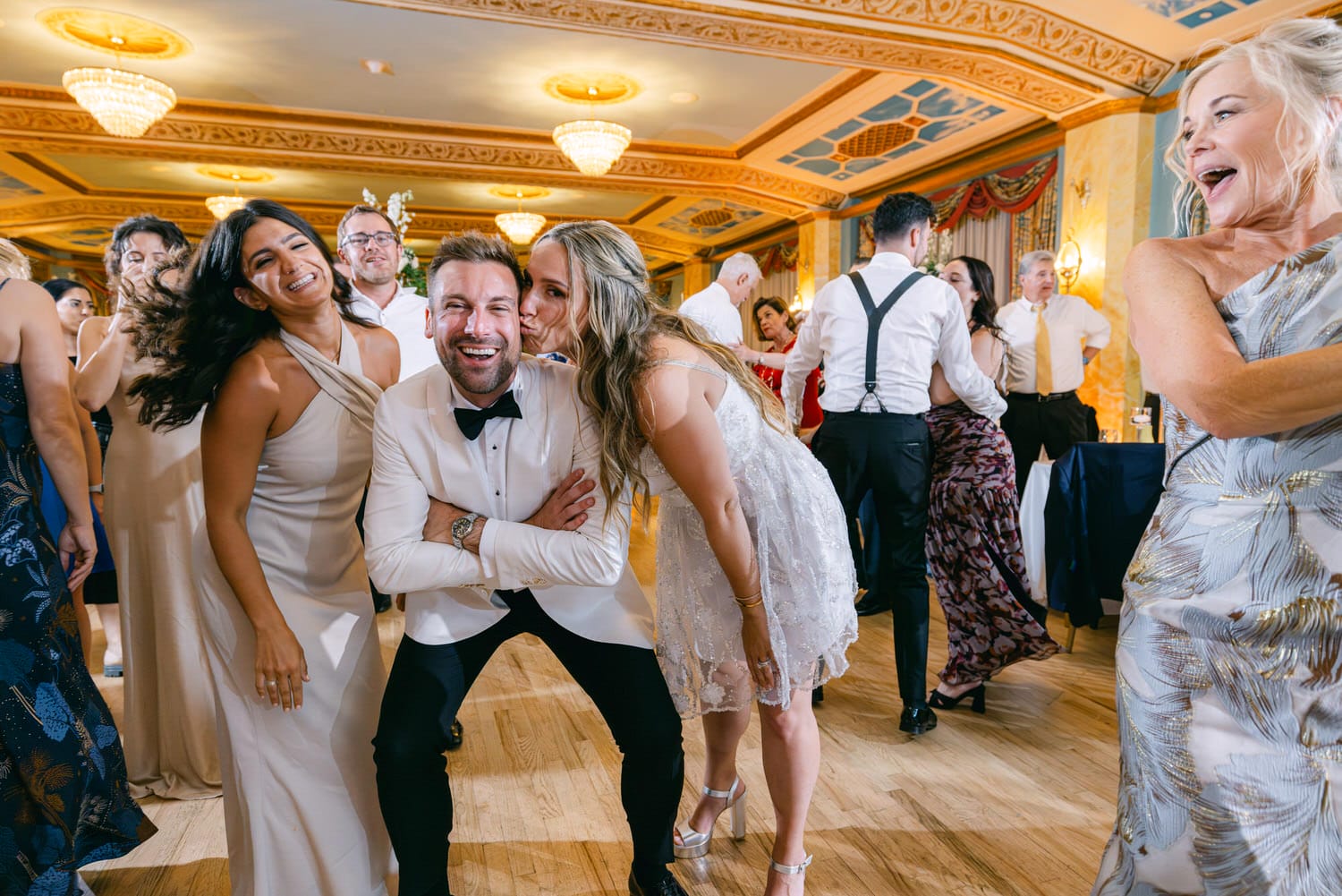 Group of friends dancing and enjoying a lively celebration, with smiles and laughter in a beautifully decorated venue.