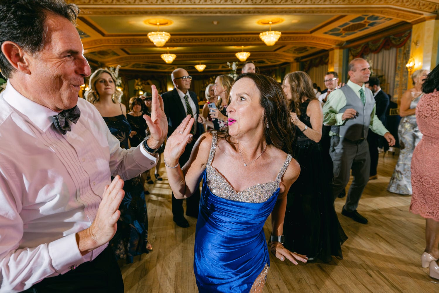 Guests enjoying a lively dance floor in a beautifully decorated venue, showcasing festive attire and joyful expressions.