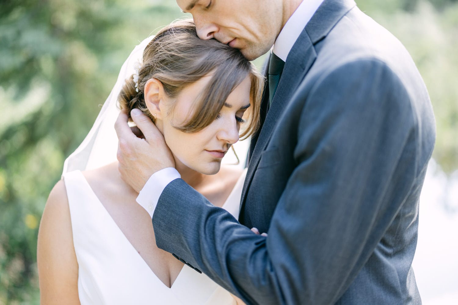 A bride and groom share a tender moment, with the groom gently resting his forehead against the bride's, highlighting their emotional connection.