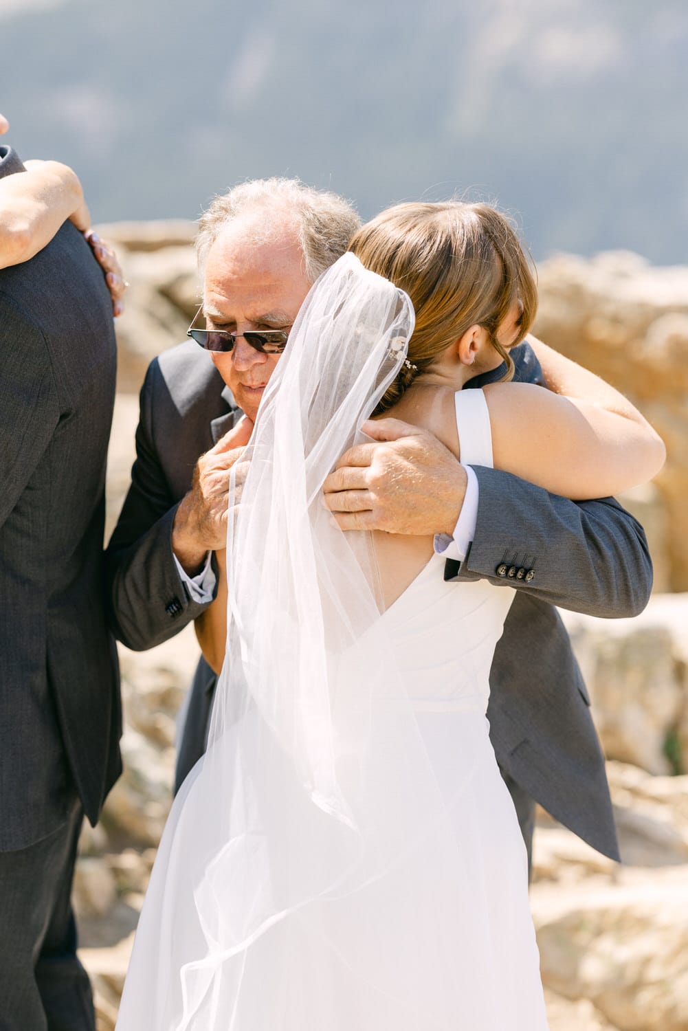 A heartfelt moment between a bride and her father, celebrating their bond during an outdoor wedding ceremony.