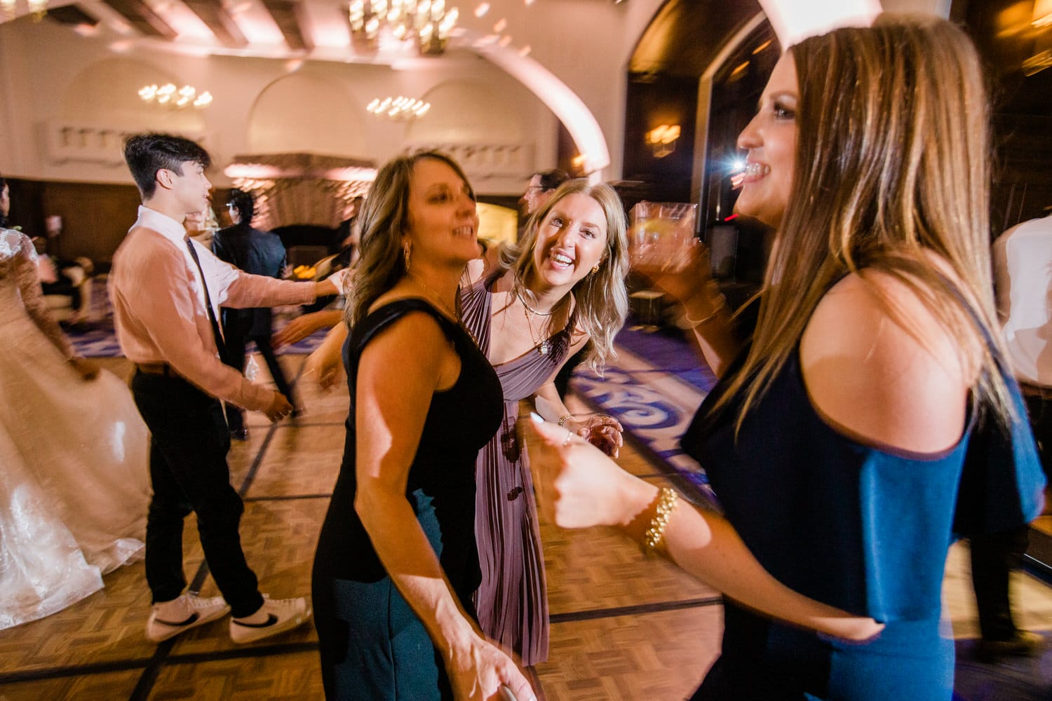 A lively scene of friends dancing and enjoying a celebration, with energetic smiles and vibrant atmosphere.