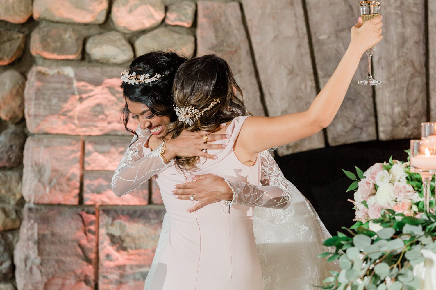 Two brides celebrate their union with a heartfelt embrace, surrounded by romantic decor and a festive atmosphere.