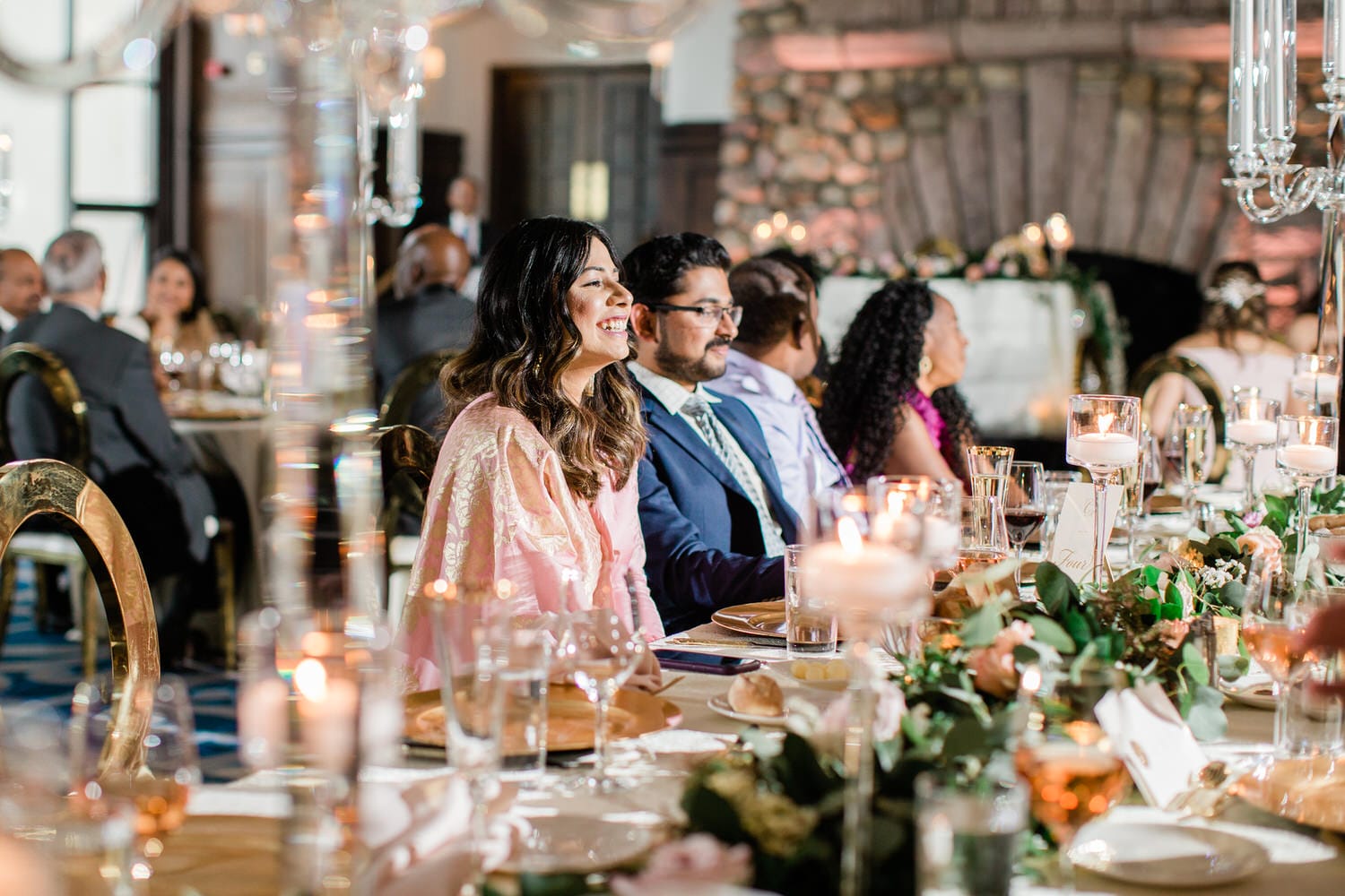 Guests enjoying a sophisticated meal at a beautifully set table, adorned with candles and floral decorations.