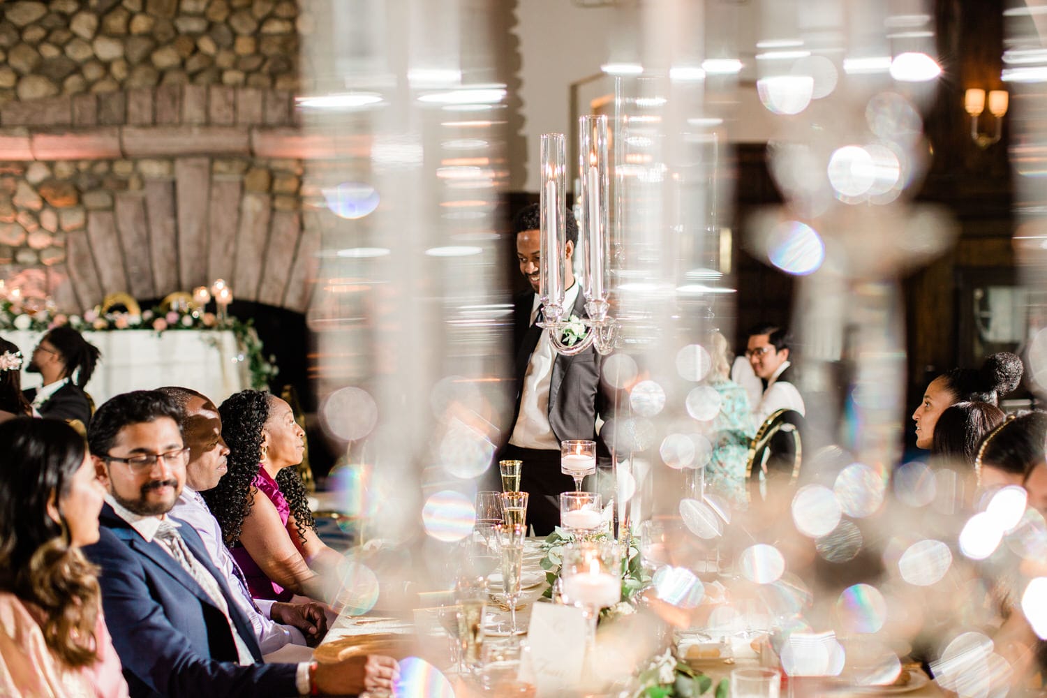 Guests enjoy a beautifully arranged dining table during a sophisticated event, with soft candlelight and floral decor.