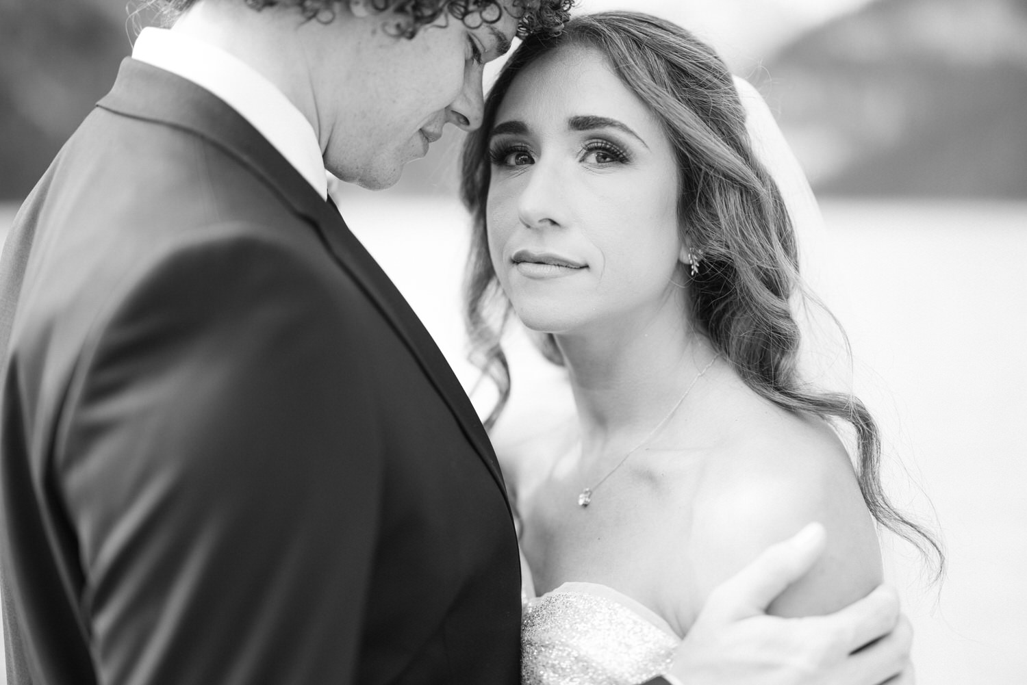 A close-up shot of a bride and groom sharing an intimate moment, with the bride gazing thoughtfully, capturing deep emotions on their wedding day.